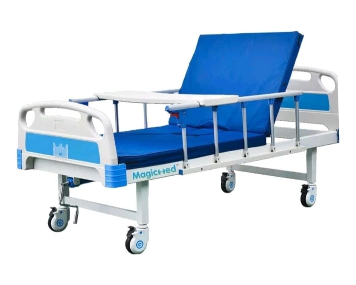 Manual hospital bed with blue mattress, side rails and an over-bed table
