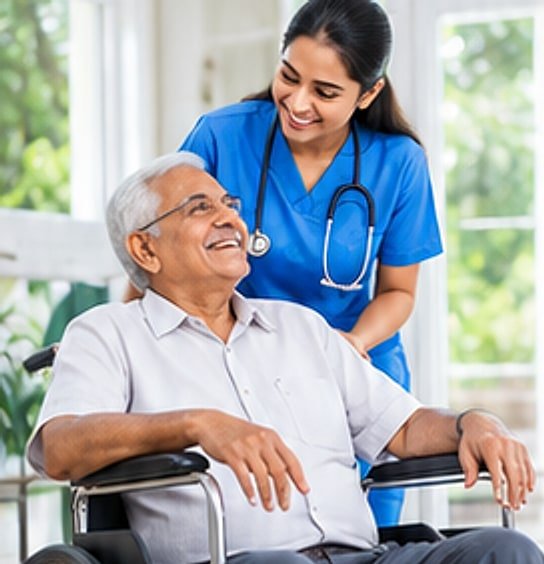 Nurse in blue scrubs assisting a smiling elderly man seated in a wheelchair